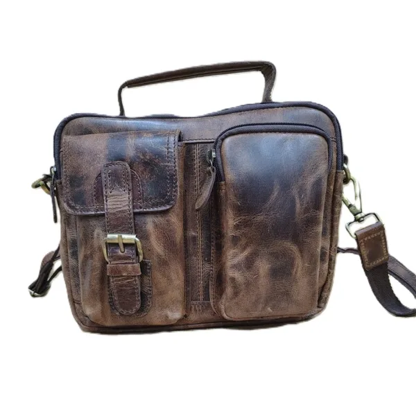 Handcrafted brown leather crossbody messenger bag with multiple front pockets, buckle strap, and adjustable shoulder strap