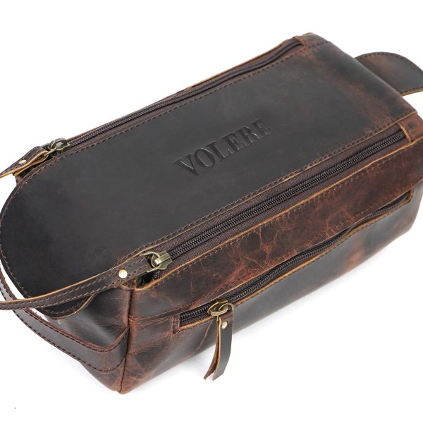 Handcrafted brown leather travel toiletry bag by Volere featuring dual zipper compartments, sturdy handle, and embossed logo on top.