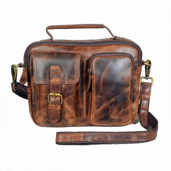 Vintage-style handmade brown leather sling bag by Volere featuring front pockets, brass buckle, and adjustable shoulder strap